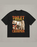 Black heavyweight tee reading TOILET CLOGGING CHAMPION in orange flame lettering around a bootleg collage of a toilet, rolls of paper and a plunger
