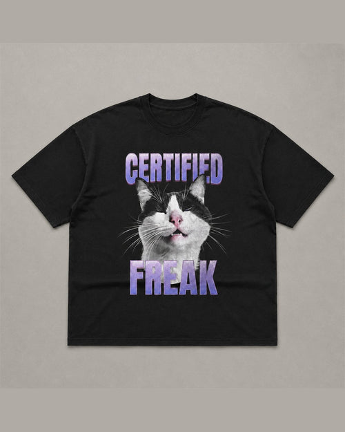 Black heavyweight tee reading CERTIFIED FREAK in purple chrome lettering above and below a close-up of a tuxedo cat